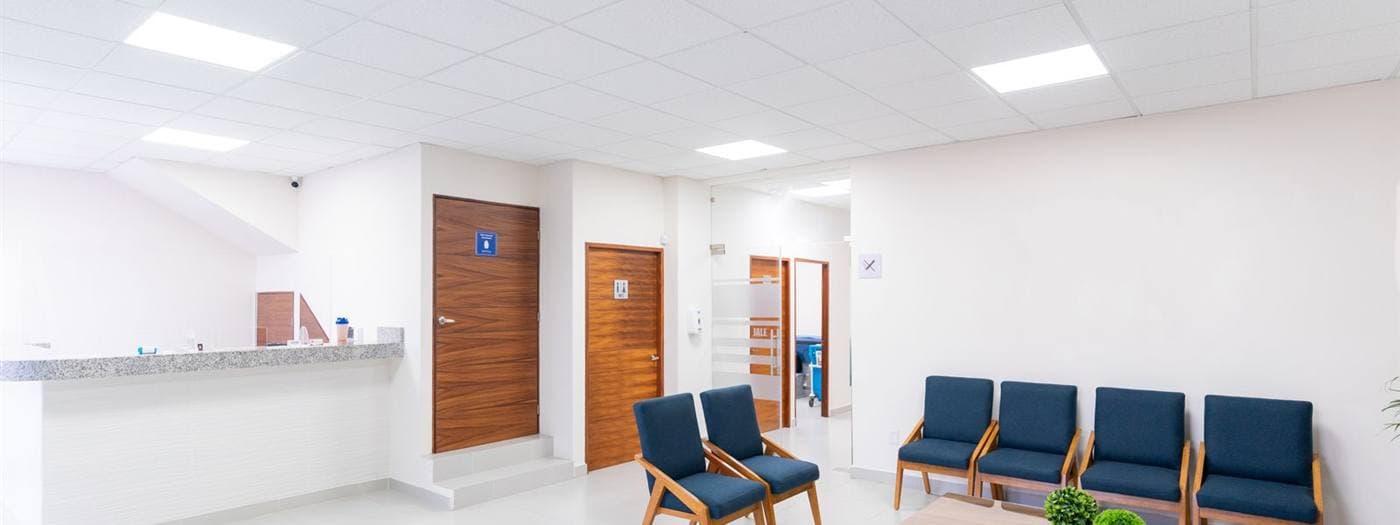 Sala de espera de clínica com fileiras de cadeiras vazias