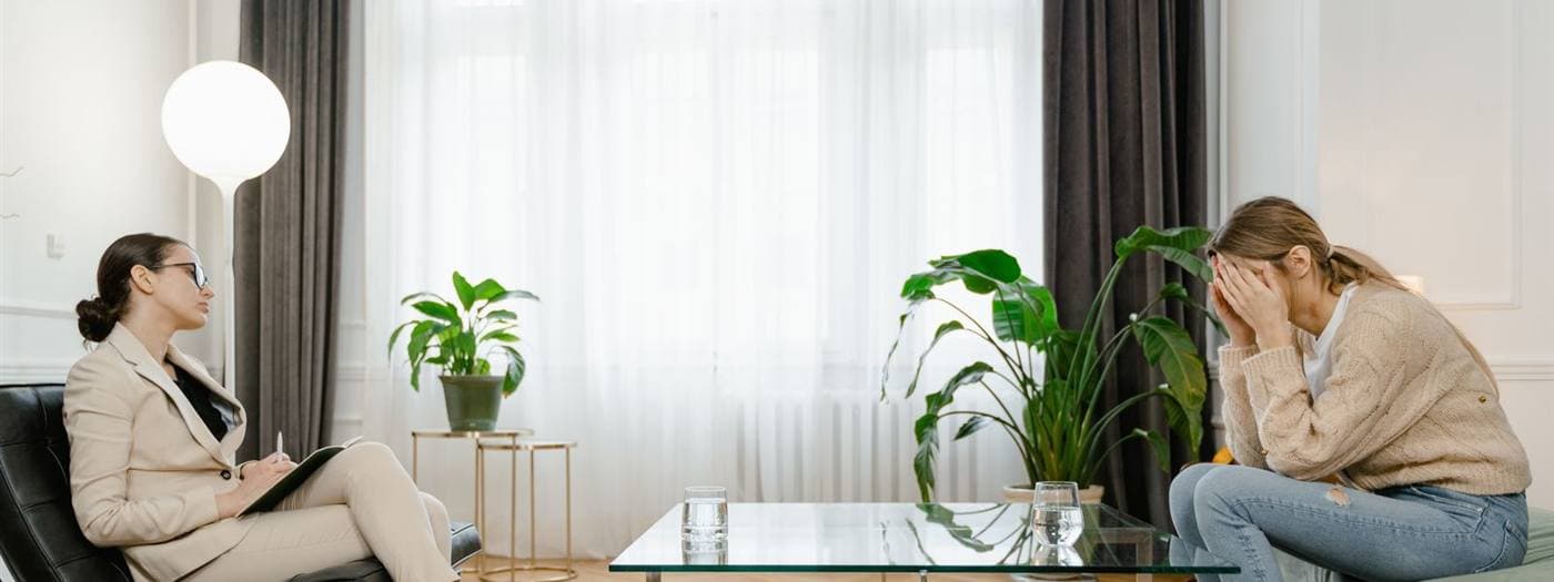 Sala de atendimento com sofá e plantas, ambiente acolhedor